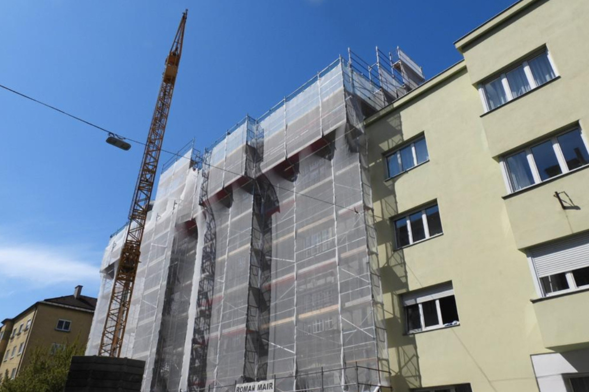 Gebäude mit Gerüst und Kran an der Fassade